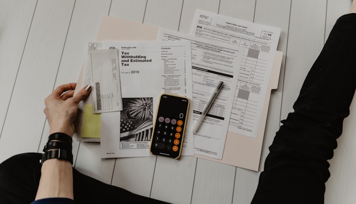 Calculator, notebook, and charts on a desk